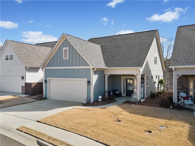 view of front of house with board and batten siding, concrete driveway, roof with shingles, and a garage