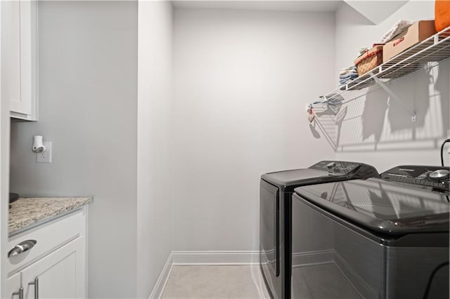 laundry room with cabinet space, washer and clothes dryer, baseboards, and tile patterned floors