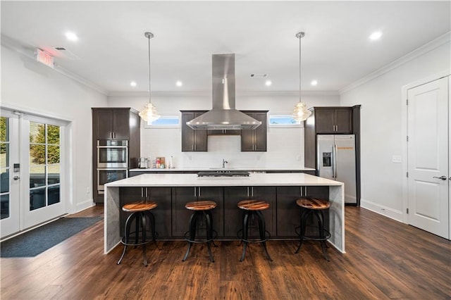 kitchen with island exhaust hood, stainless steel appliances, a spacious island, light countertops, and ornamental molding