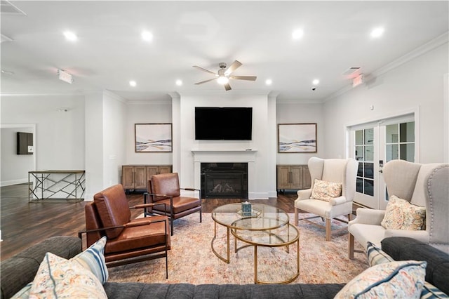 living area featuring ornamental molding, a glass covered fireplace, french doors, and wood finished floors