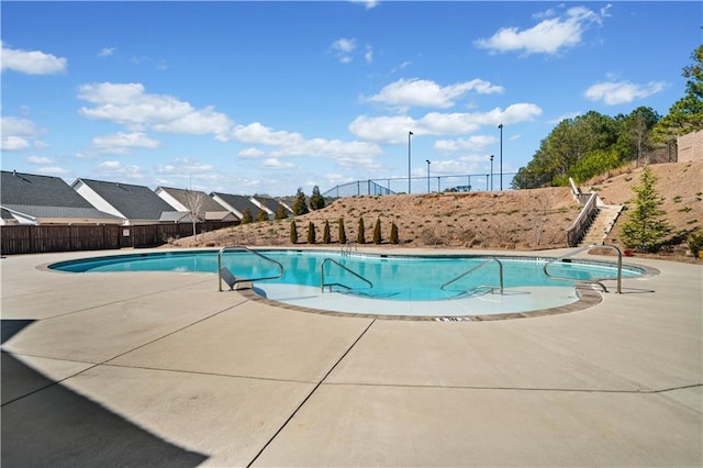 community pool featuring a patio area and fence