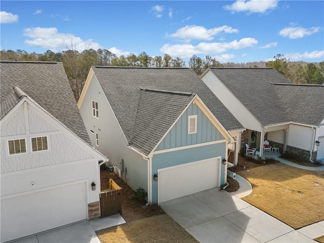 view of front of home featuring a garage, driveway, board and batten siding, and roof with shingles