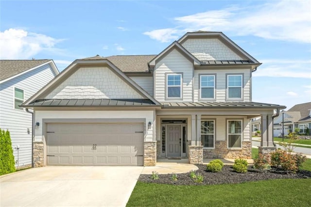 craftsman inspired home featuring a porch, stone siding, a standing seam roof, and concrete driveway