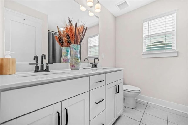 full bath with toilet, tile patterned flooring, a sink, and baseboards