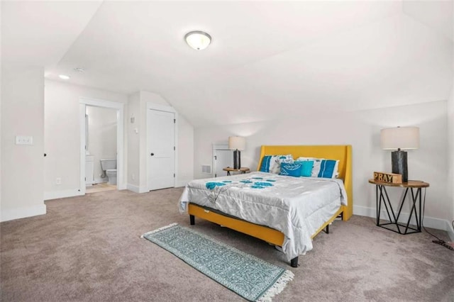 carpeted bedroom featuring lofted ceiling, baseboards, and ensuite bathroom