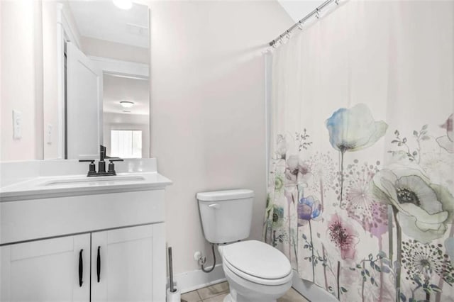 bathroom with baseboards, toilet, and vanity
