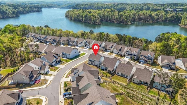 drone / aerial view with a view of trees, a residential view, and a water view
