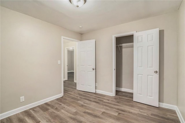 unfurnished bedroom with hardwood / wood-style floors and a closet