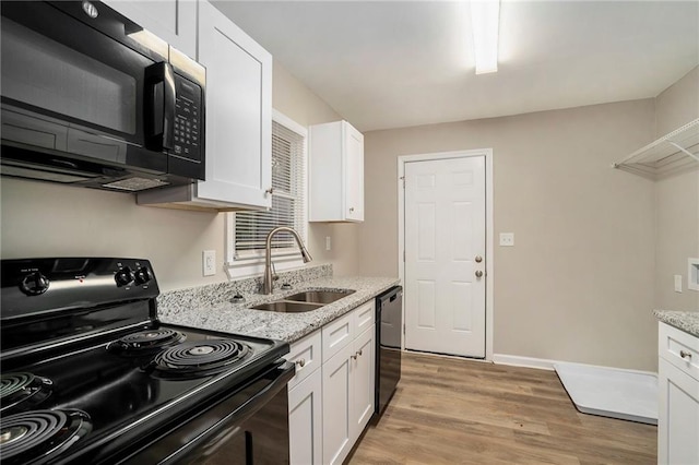 kitchen with light stone counters, black appliances, and white cabinets