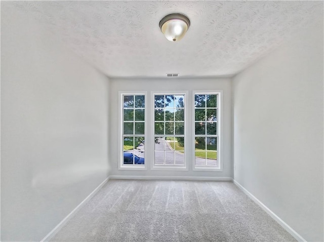 doorway with carpet and a textured ceiling