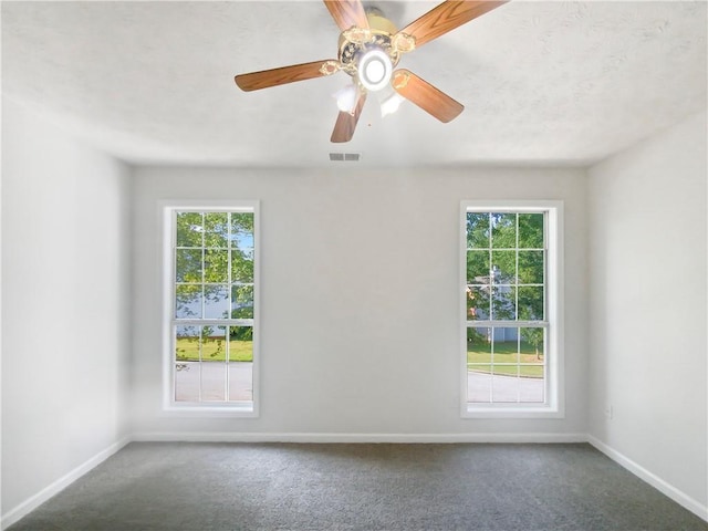 spare room with ceiling fan and carpet