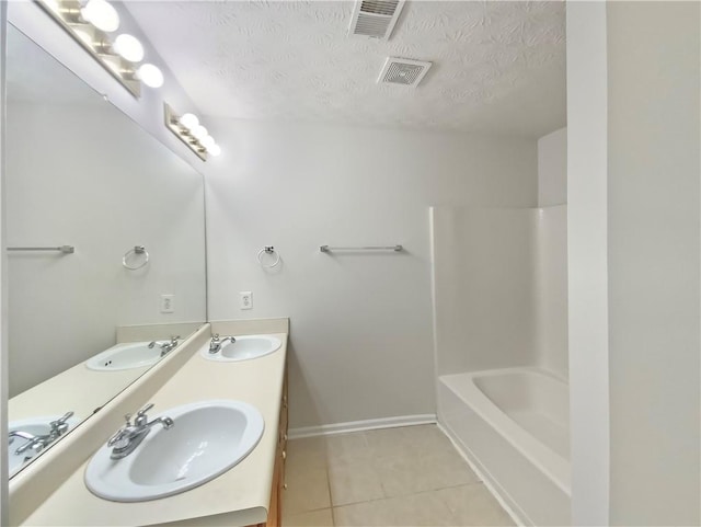 bathroom featuring a textured ceiling, vanity, tile patterned flooring, and tub / shower combination