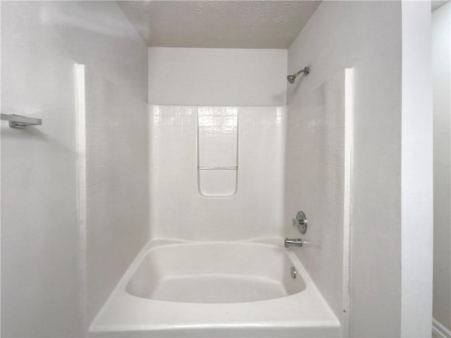 bathroom featuring shower / bathtub combination and a textured ceiling