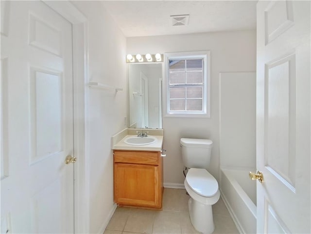 bathroom featuring vanity, tile patterned flooring, toilet, and a bathing tub