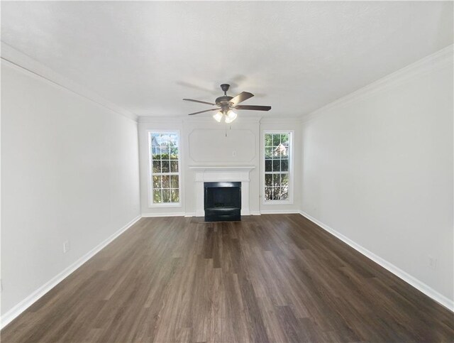 unfurnished living room featuring a wealth of natural light, ceiling fan, ornamental molding, and dark hardwood / wood-style floors