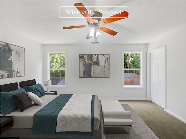 bedroom with carpet floors, multiple windows, and ceiling fan