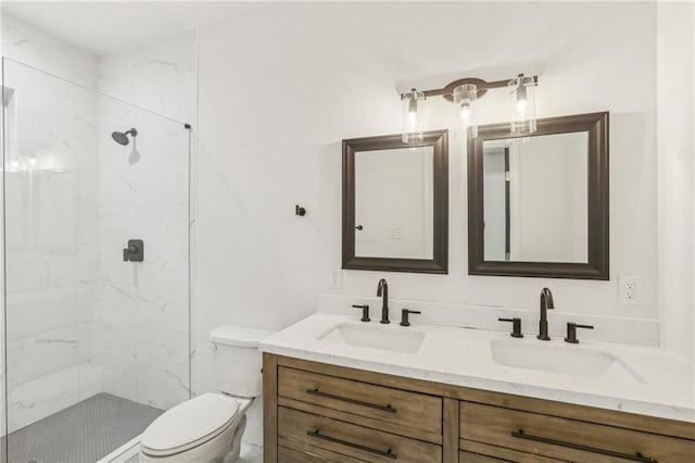 bathroom with a tile shower, vanity, and toilet