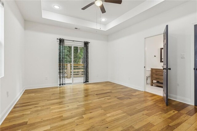 spare room with lofted ceiling and light wood-type flooring