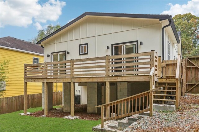 rear view of property with a wooden deck, a yard, and cooling unit