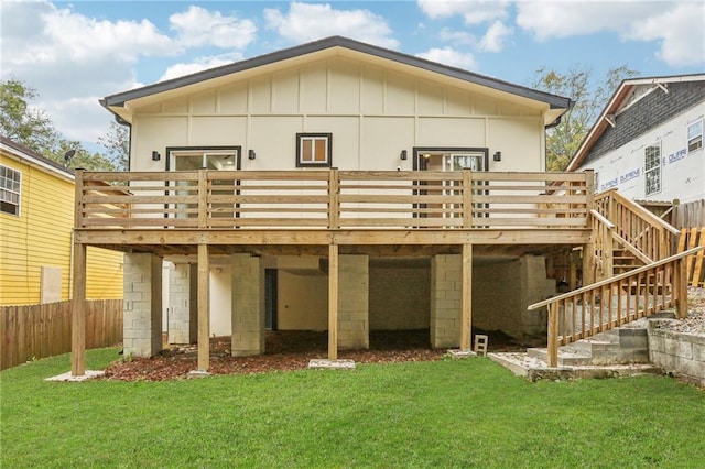 rear view of house featuring a lawn and a deck