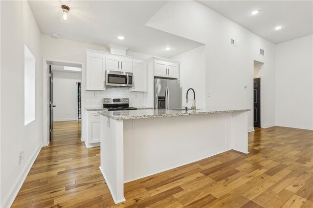 kitchen featuring white cabinetry, sink, light stone counters, and stainless steel appliances