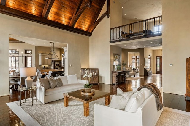 living area featuring beam ceiling, a healthy amount of sunlight, high vaulted ceiling, a chandelier, and hardwood / wood-style flooring