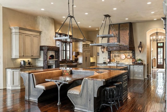 kitchen with arched walkways, a high ceiling, recessed lighting, and dark wood-type flooring