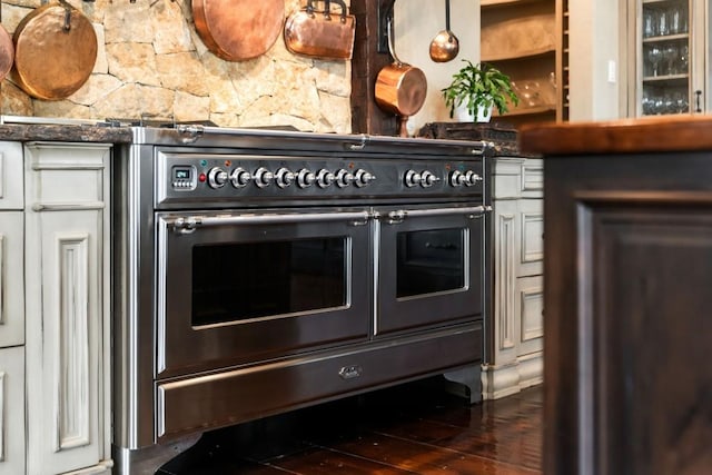 details with glass insert cabinets, white cabinetry, and range with two ovens