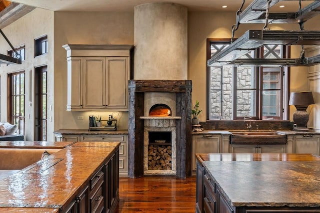 kitchen with dark wood-type flooring, a sink, recessed lighting, and a fireplace