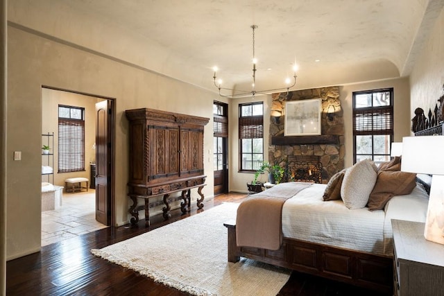 bedroom featuring baseboards, multiple windows, hardwood / wood-style flooring, and a chandelier