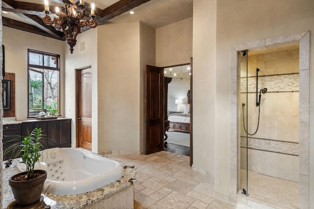 full bathroom featuring an inviting chandelier, a jetted tub, beamed ceiling, stone tile flooring, and a stall shower