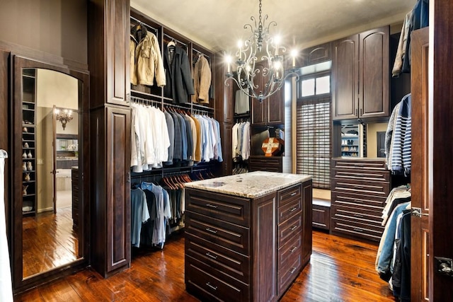 spacious closet featuring a chandelier and dark wood finished floors