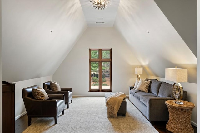 living area with baseboards, visible vents, and lofted ceiling
