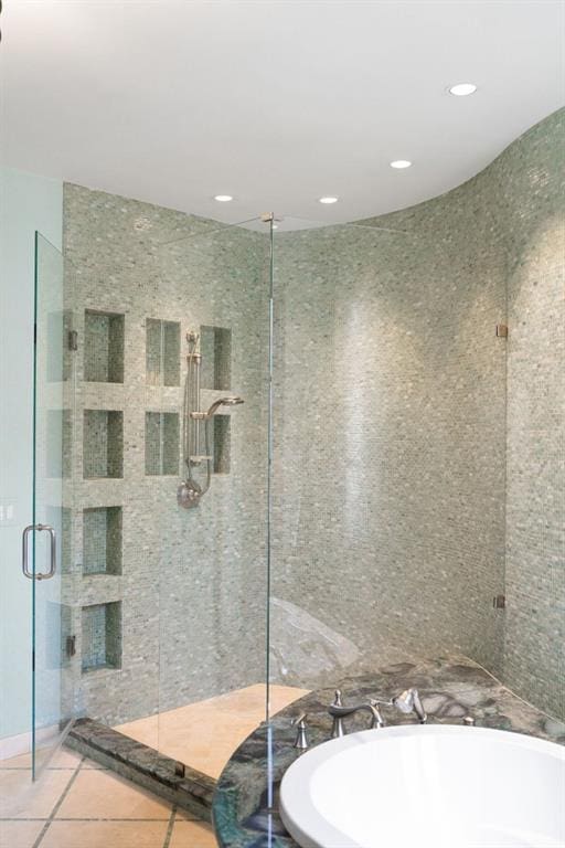 full bath featuring recessed lighting, a freestanding tub, a shower stall, and tile patterned floors