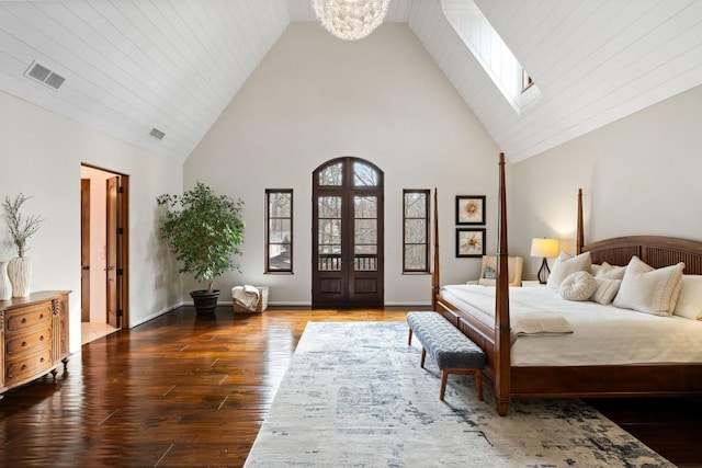bedroom with a notable chandelier, high vaulted ceiling, wood finished floors, a skylight, and visible vents