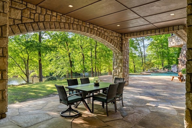 view of patio with outdoor dining area and an outdoor pool