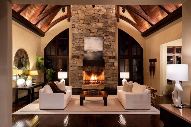 interior space featuring high vaulted ceiling, a stone fireplace, hardwood / wood-style floors, wooden ceiling, and beamed ceiling