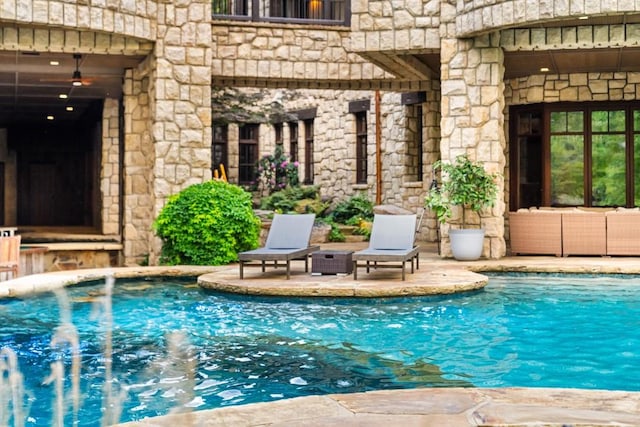 pool with an outdoor living space and a patio area