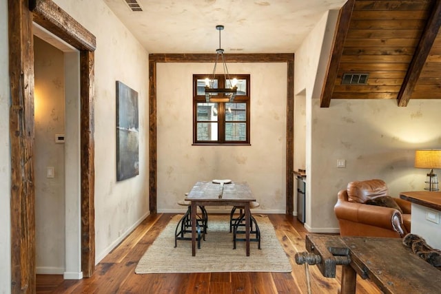 dining room featuring baseboards, visible vents, hardwood / wood-style flooring, and a chandelier