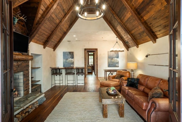 living area with a stone fireplace, wooden ceiling, a notable chandelier, vaulted ceiling with beams, and hardwood / wood-style floors