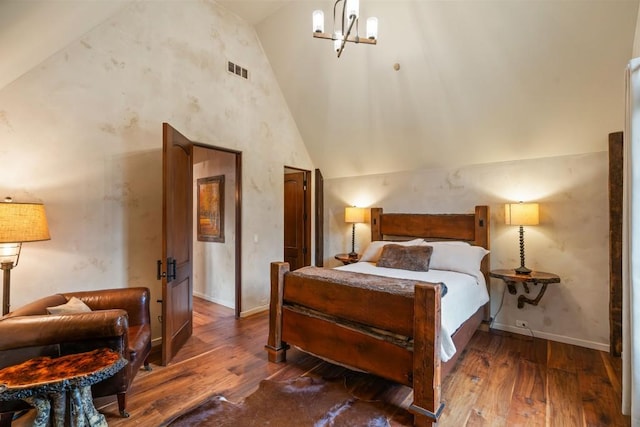 bedroom with an inviting chandelier, high vaulted ceiling, hardwood / wood-style floors, baseboards, and visible vents