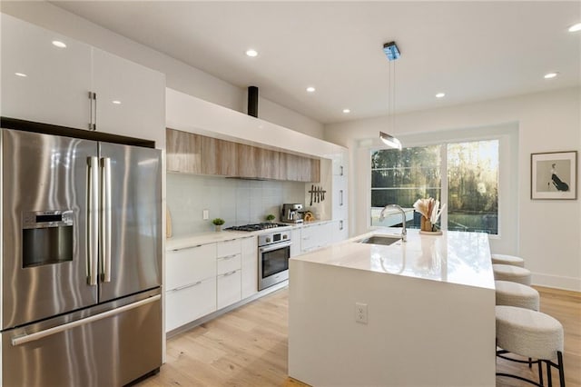 1045 Shepherds Ln NE, Atlanta, GA 30324 - kitchen featuring a sink, decorative backsplash, stainless steel appliances, light wood-style floors, and modern cabinets