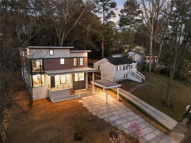 1045 Shepherds Ln NE, Atlanta, GA 30324 - back of house at dusk featuring covered porch and driveway
