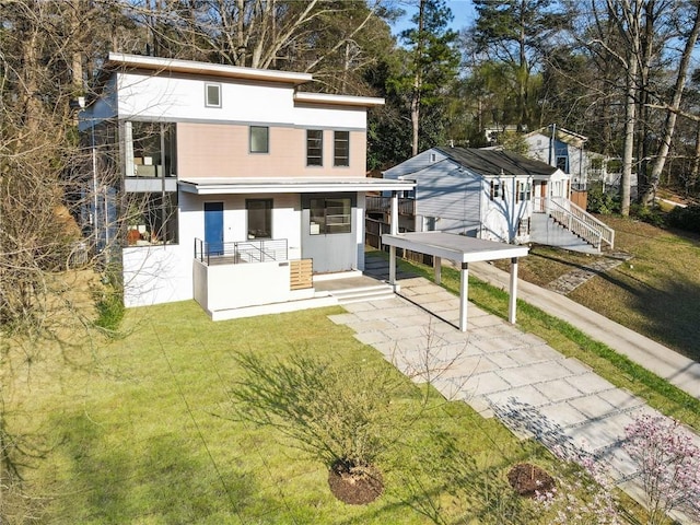 1045 Shepherds Ln NE, Atlanta, GA 30324 - view of front facade with driveway, a porch, stucco siding, a carport, and a front lawn