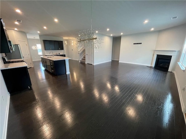 3172 Lowell Rd, Bethlehem, GA 30620 - unfurnished living room featuring recessed lighting, a glass covered fireplace, stairway, and dark wood-type flooring