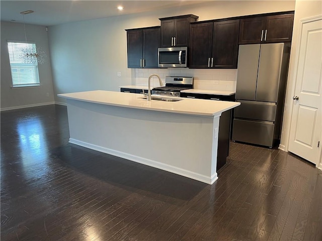 3172 Lowell Rd, Bethlehem, GA 30620 - kitchen featuring stainless steel appliances, light countertops, tasteful backsplash, dark wood-style flooring, and a center island with sink