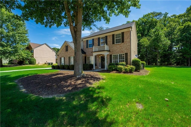 view of front of house featuring brick siding and a front yard