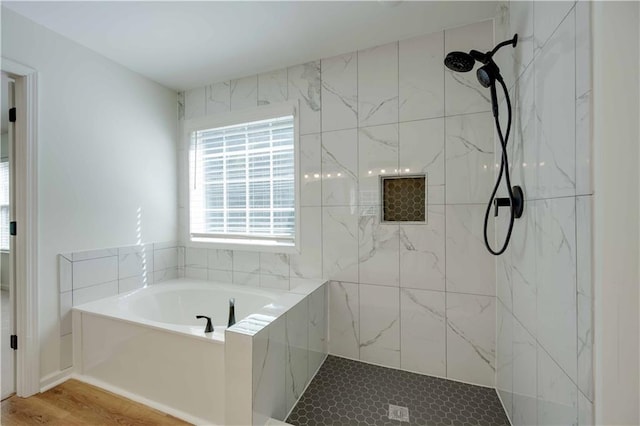 full bath featuring a garden tub and a tile shower