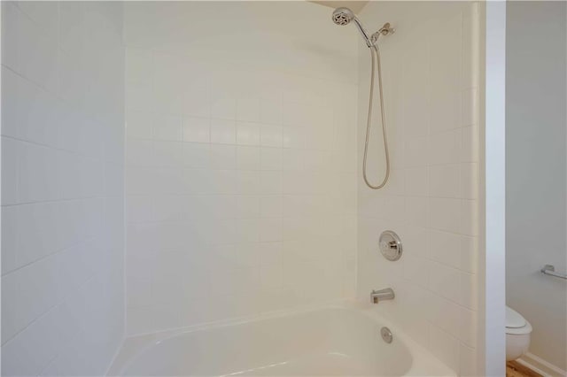 bathroom with washtub / shower combination and toilet