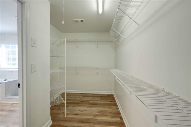 walk in closet featuring wood finished floors and visible vents